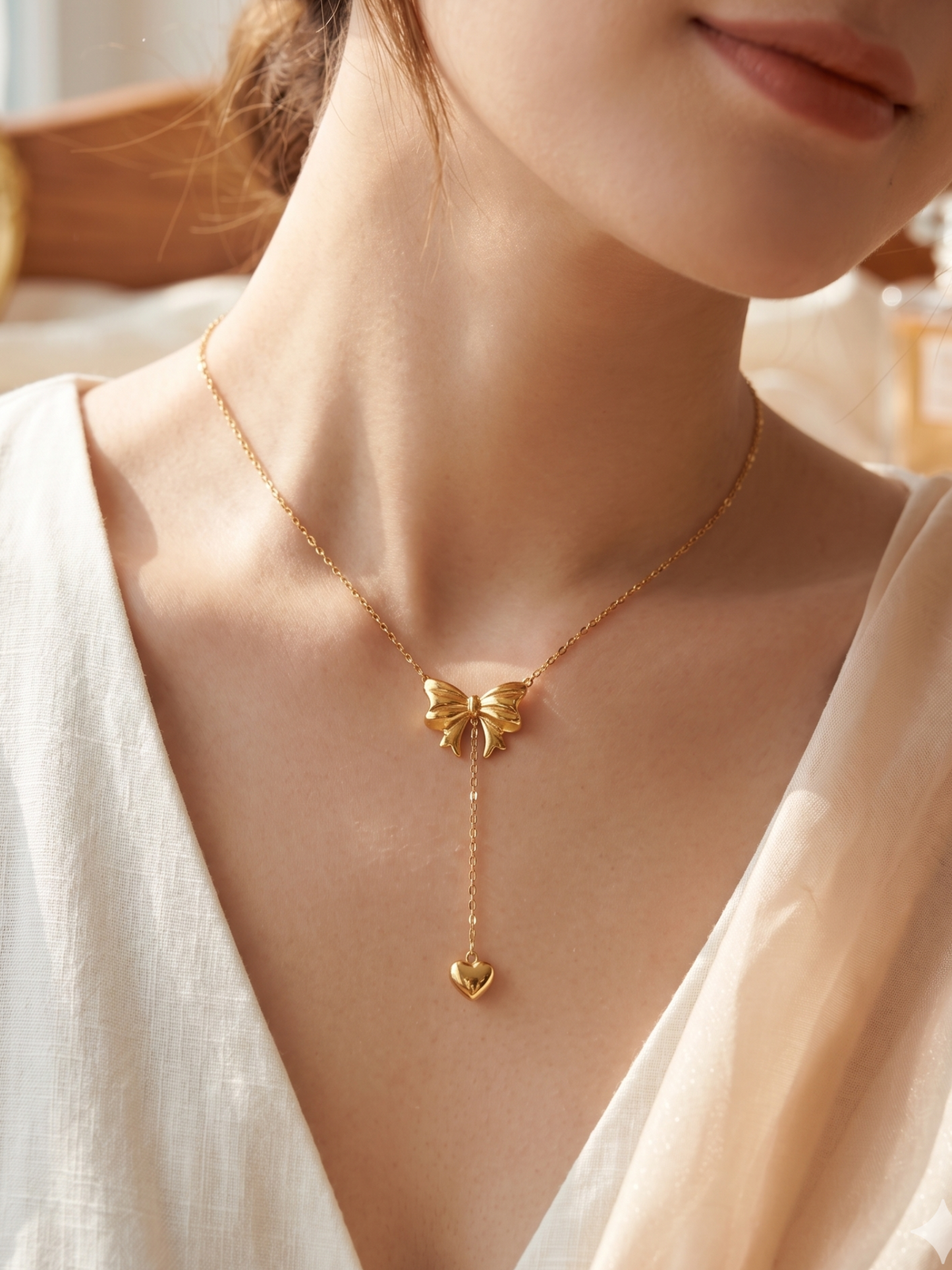 Gold butterfly necklace on a person wearing a white top