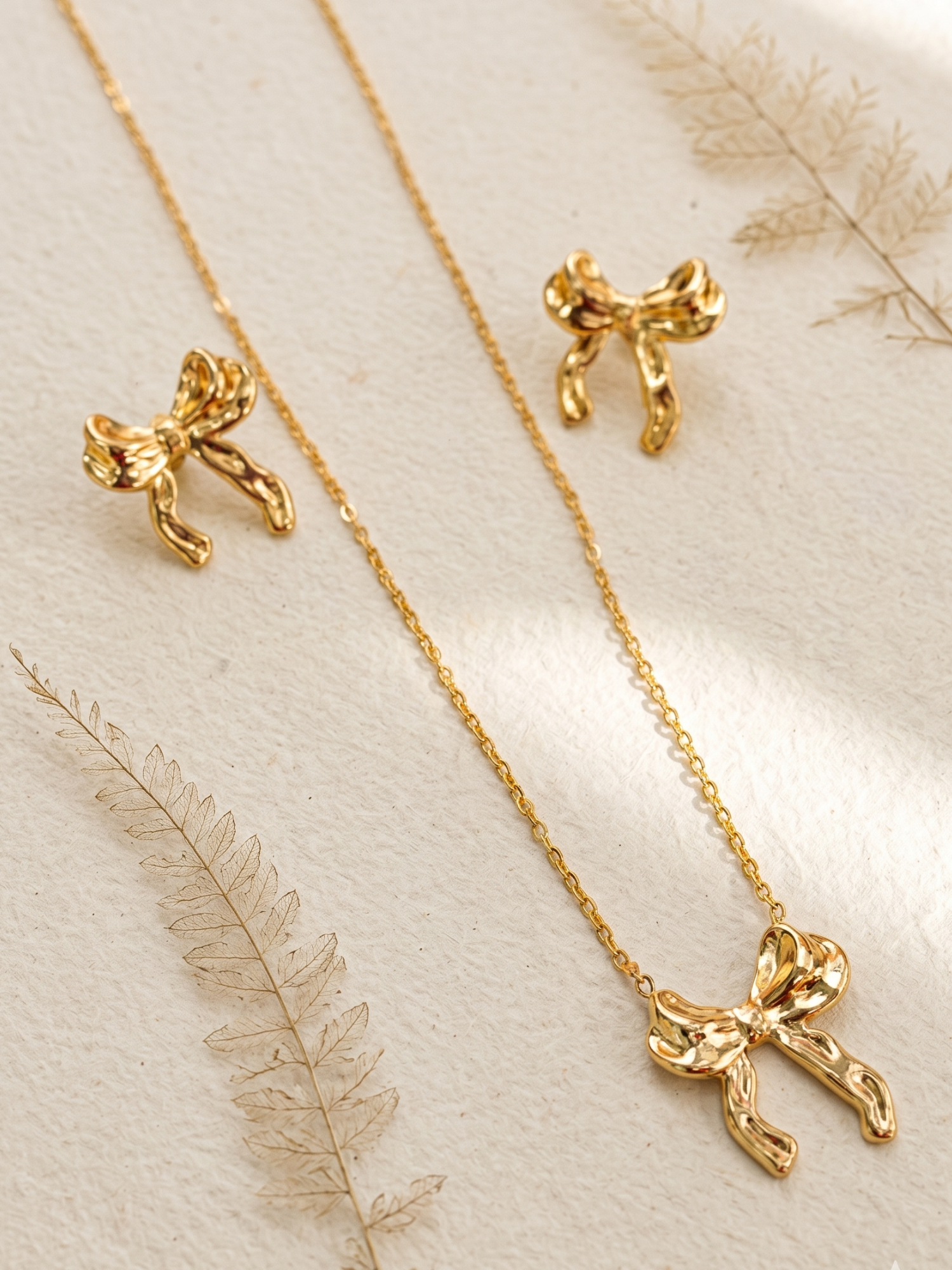 Gold bow-shaped jewelry set including necklace and earrings 
