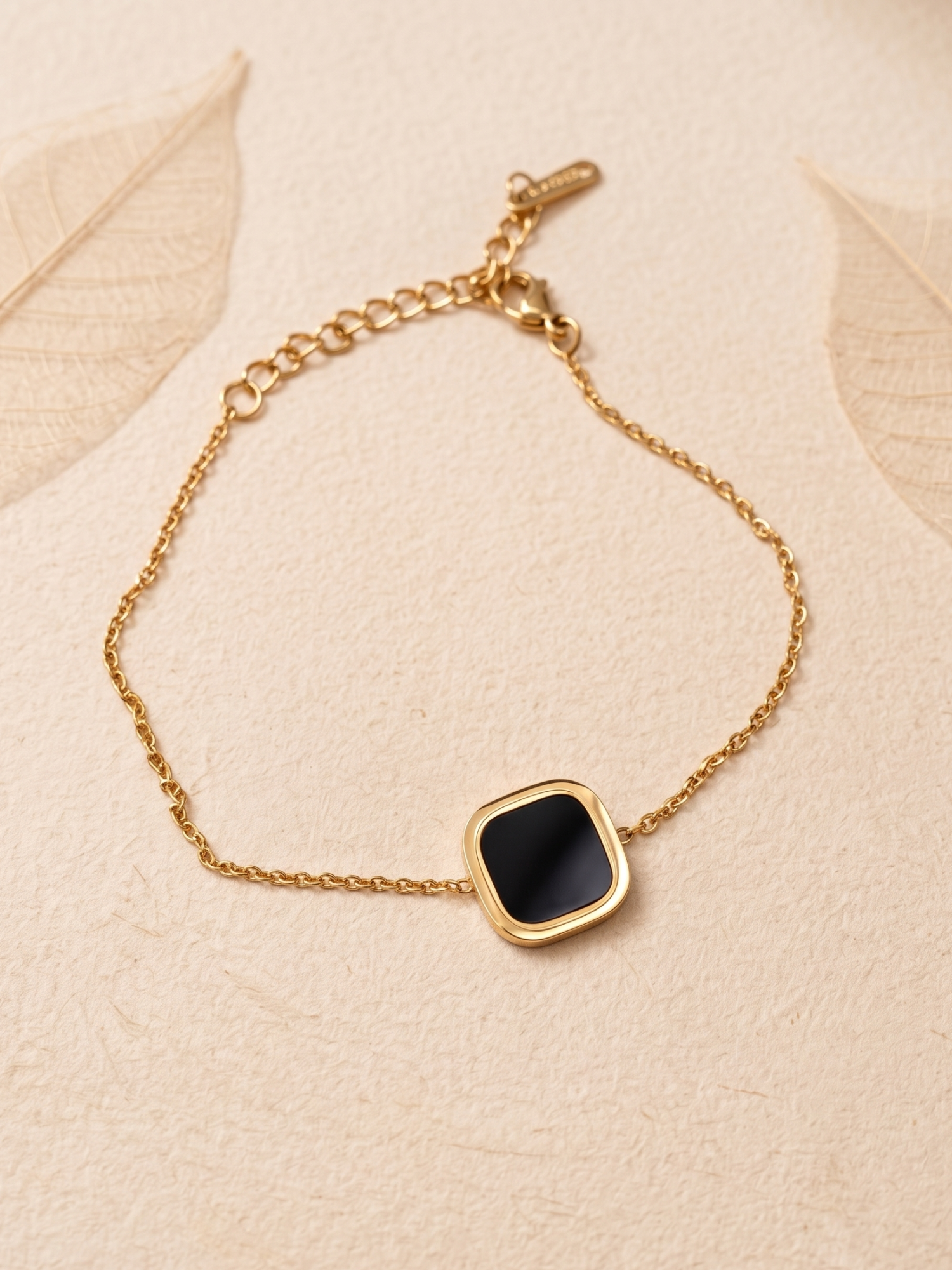 Gold bracelet with a black square stone
