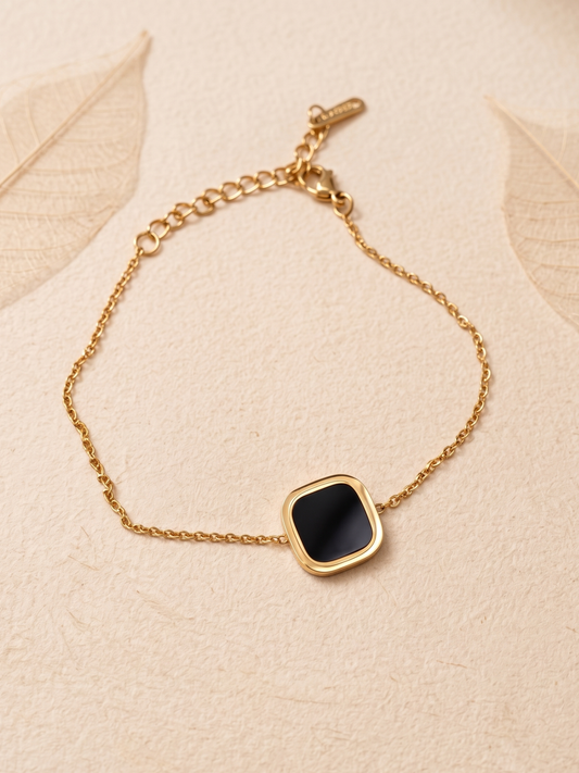 Gold bracelet with a black square stone