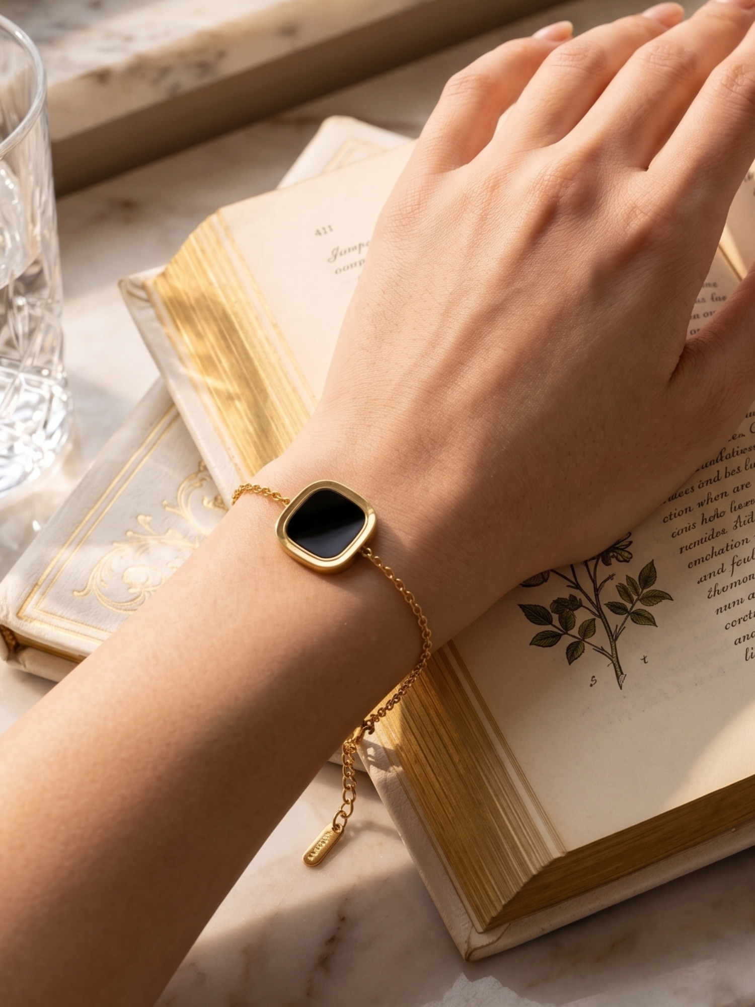 Gold bracelet with a black square stones