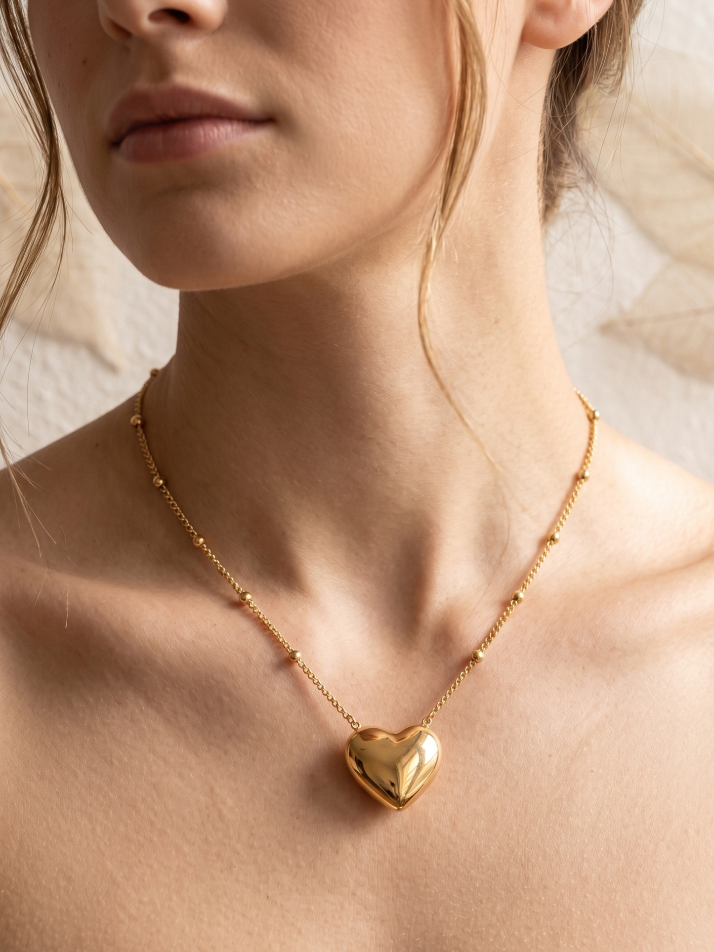 Gold lookalike heart-shaped pendant necklace on a light background
