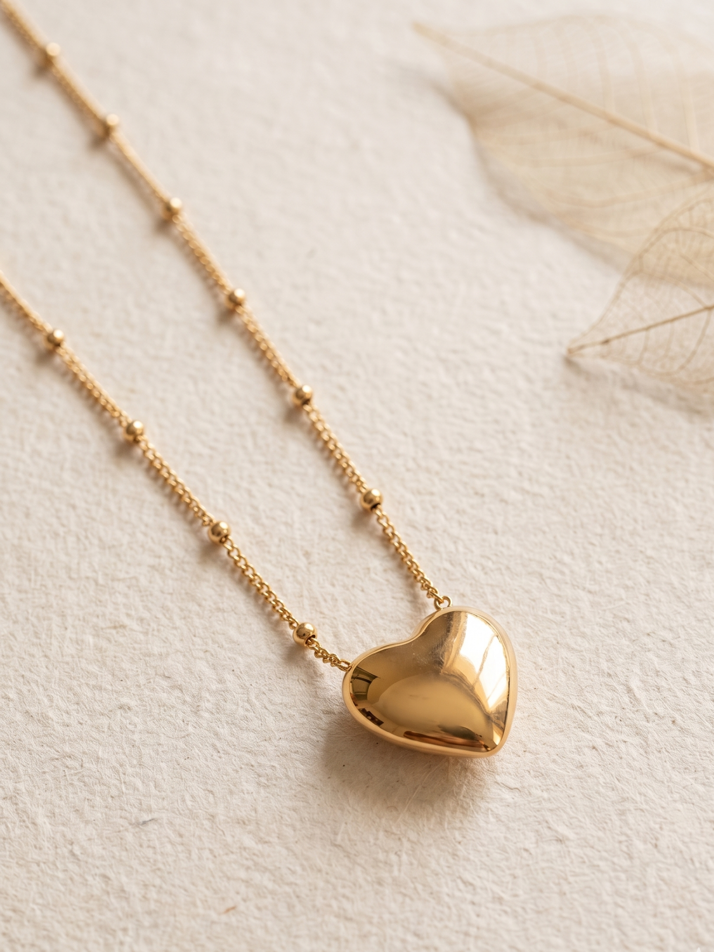 Gold lookalike heart-shaped pendant necklace on a light background