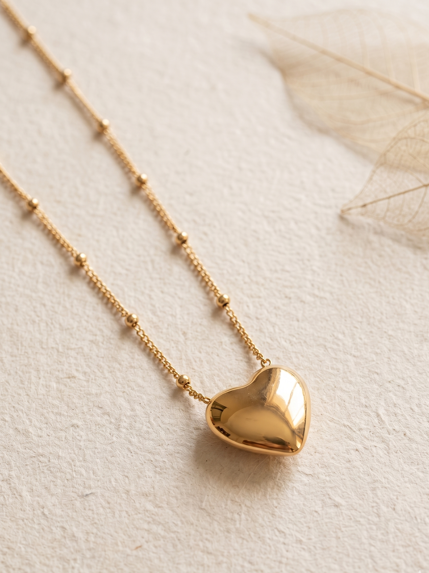 Gold lookalike heart-shaped pendant necklace on a light background