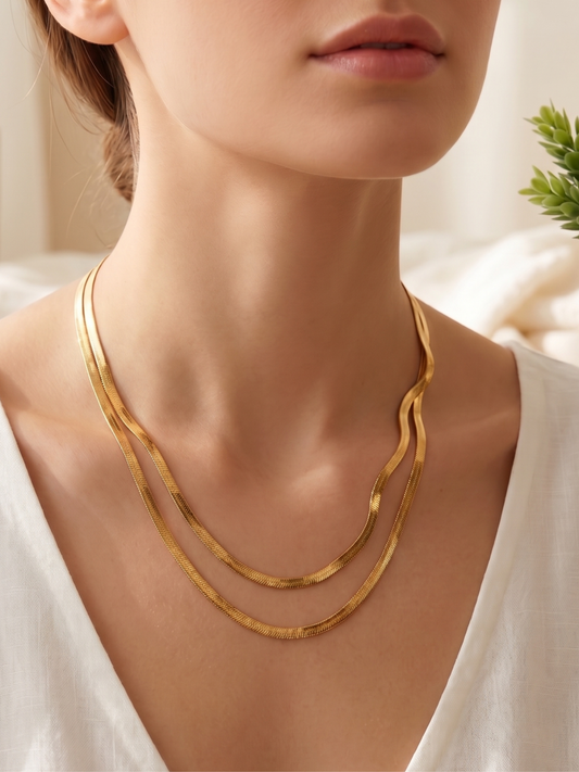 Gold necklace on a model with a neutral background