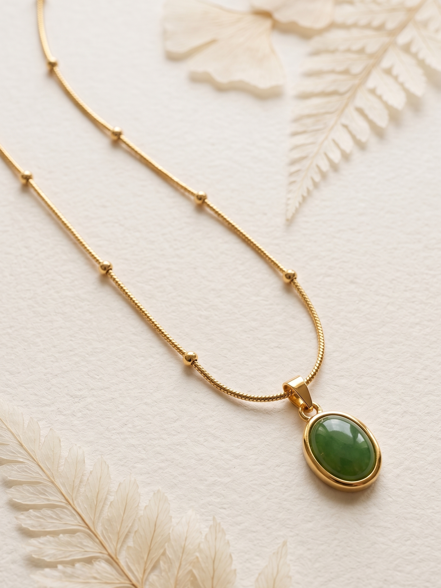 Gold necklace with a green pendant