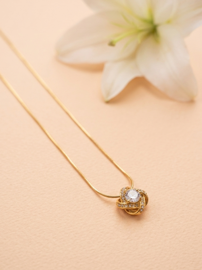 Gold necklace with a heart-shaped pendant on a beige background