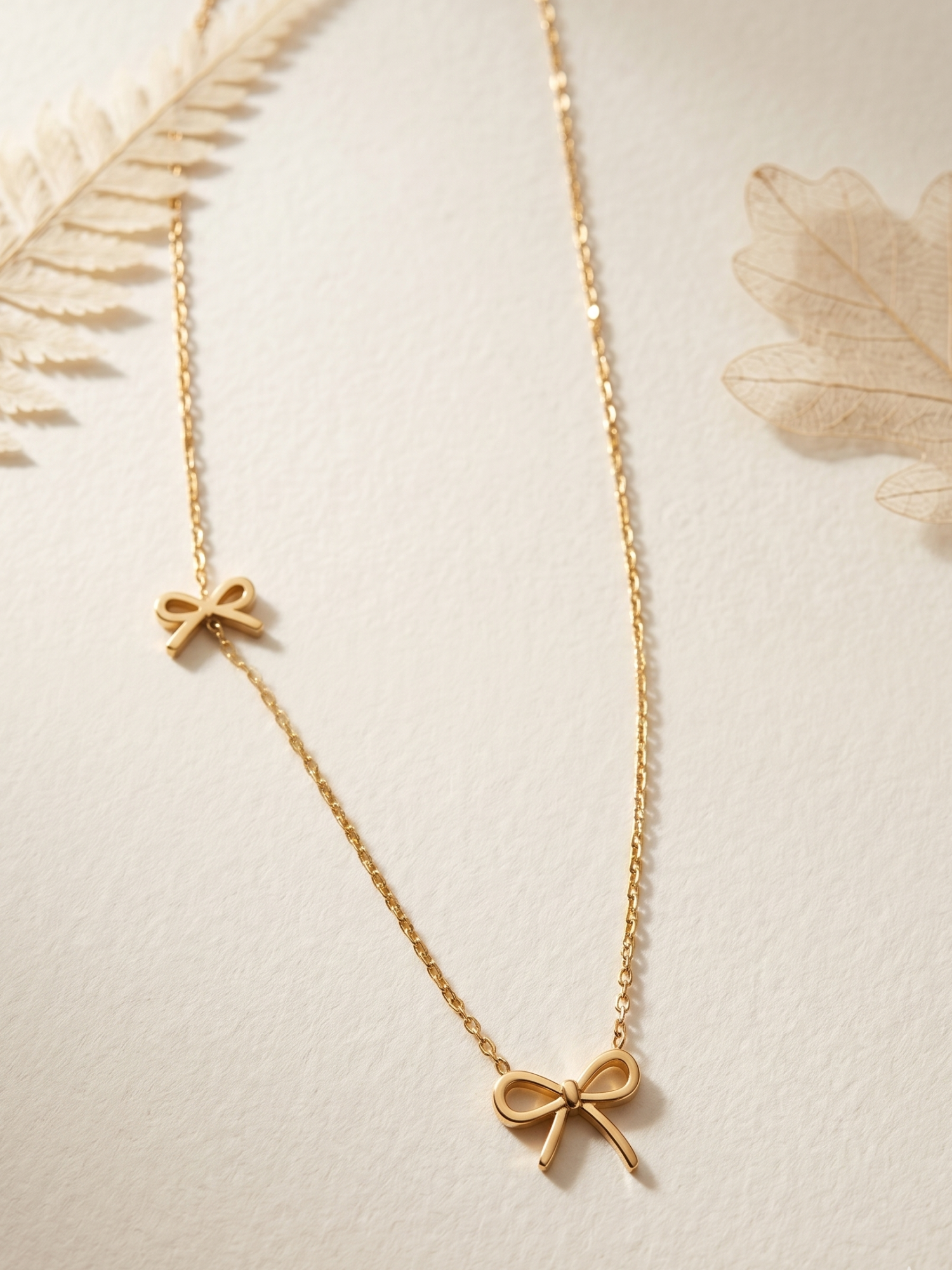 Gold necklace with two bow pendants 