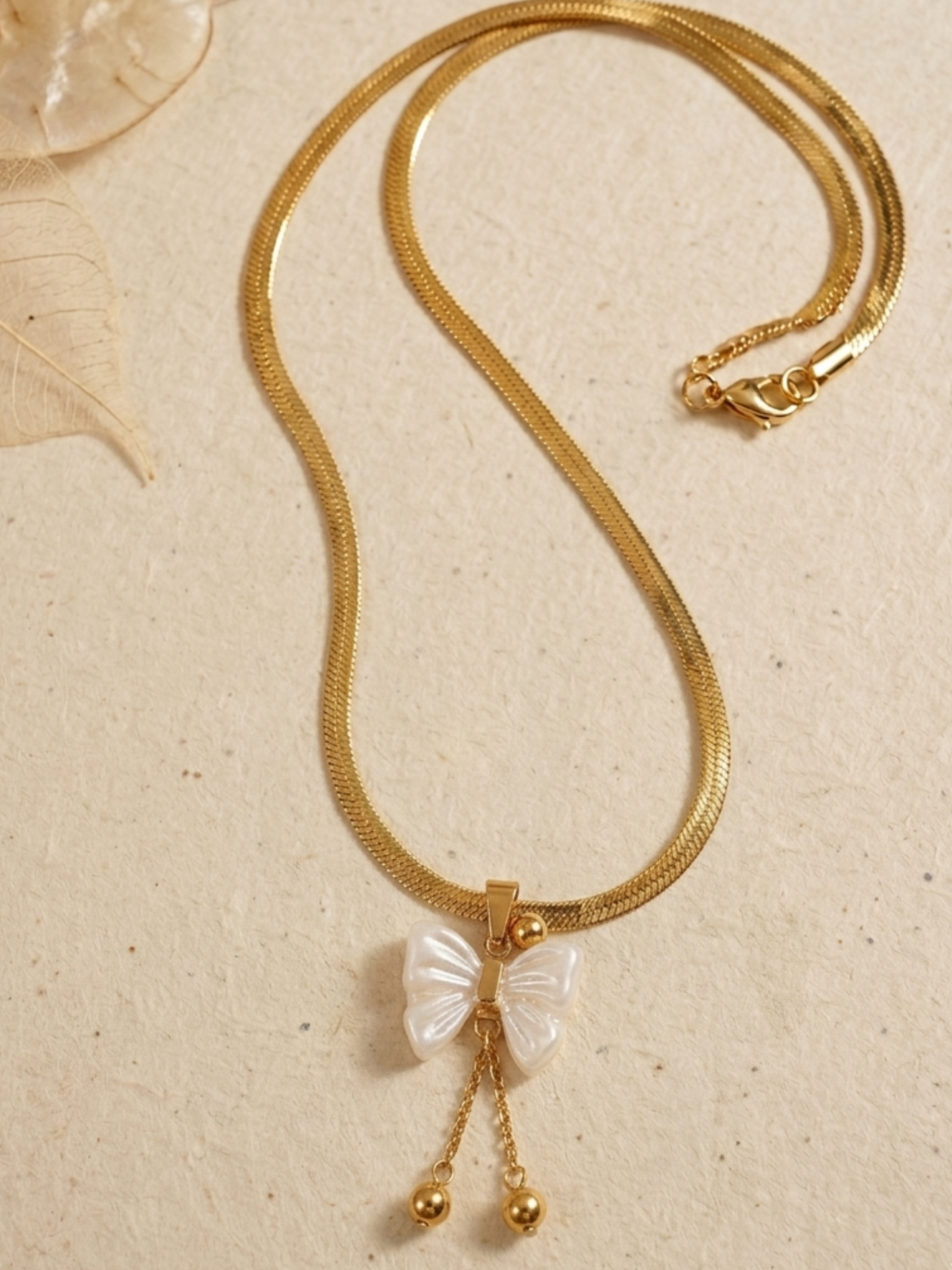 Gold toned necklace with a bow-shaped pendant