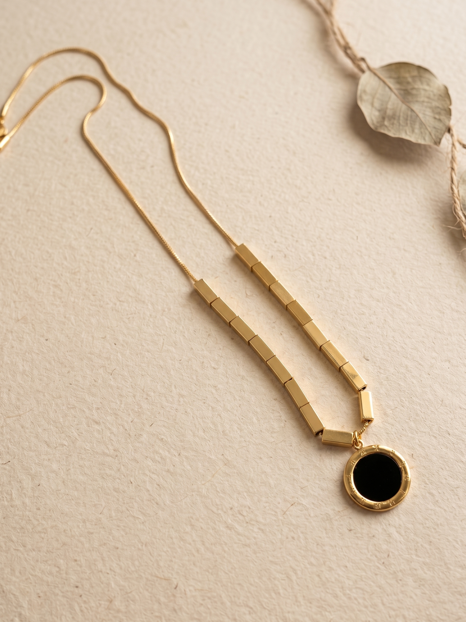 Golden necklace with a black pendant
